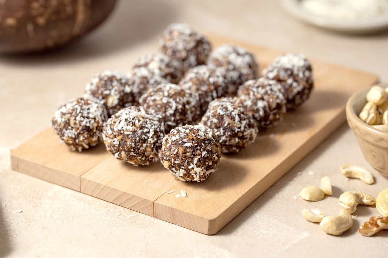 Wooden board with oat peanut butter seed bites in a row.