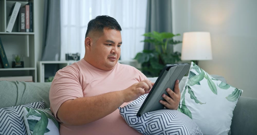 Hombre sentado en un sillón con ipad