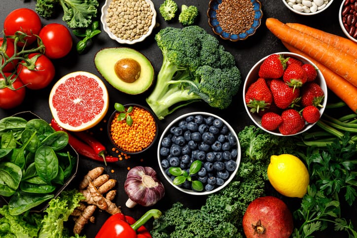 An assortment of colorful fruits, vegetables, legumes and other plant-based foods.