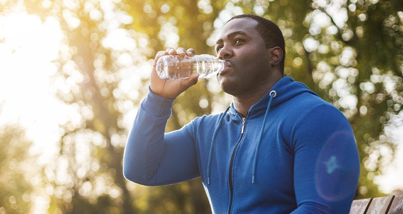 A healthy black man drinking water. 