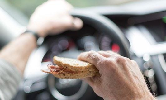 Person eating a sandwich in the car