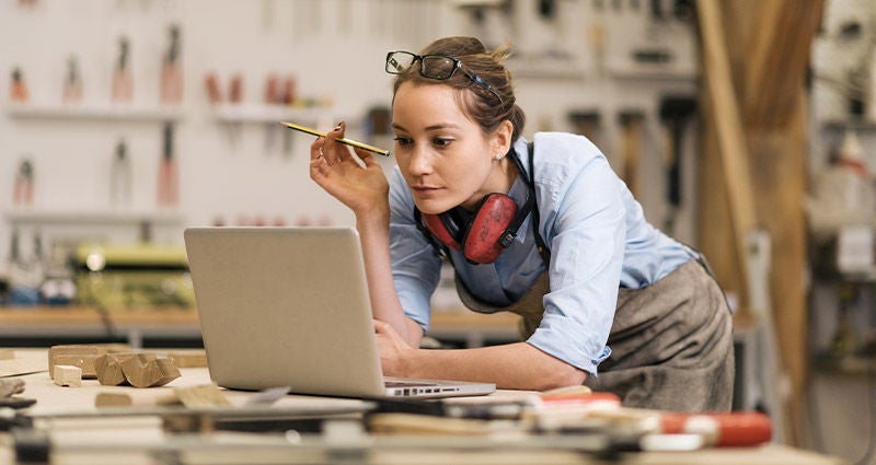 Young woman at a desk, surveying all her work.