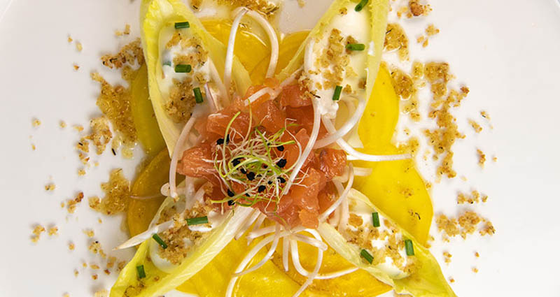 Belgian endive leaves plated and topped with goat cheese and fresh herbs