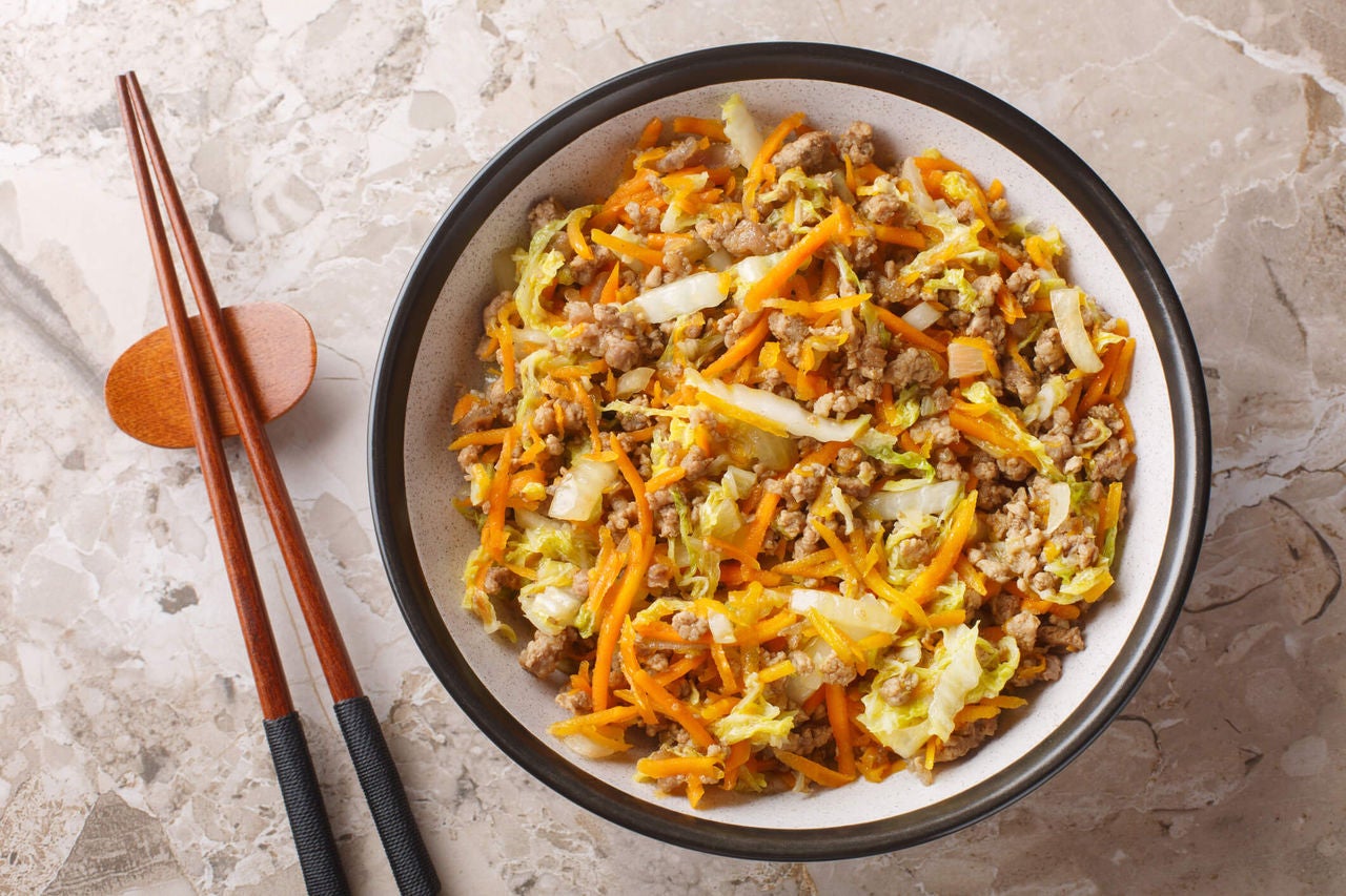 Egg roll in a bowl with ground turkey, carrots and sesame seeds.