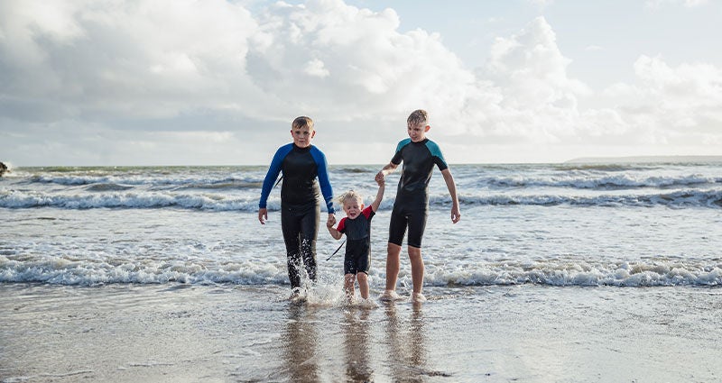 Three boys swimming in the ocean. 