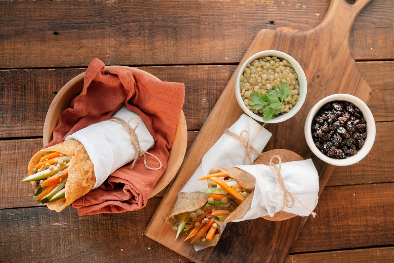 Wrap with zuchinni, carrots and lentils with ramekins full of lentils and raisins on the side.