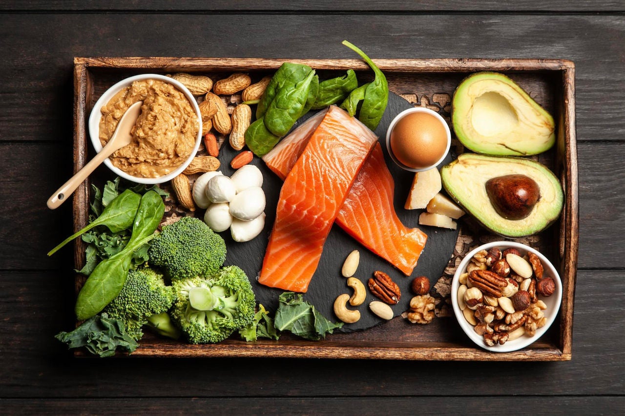 Tray of low-carb foods like salmon, vegetables and nuts.