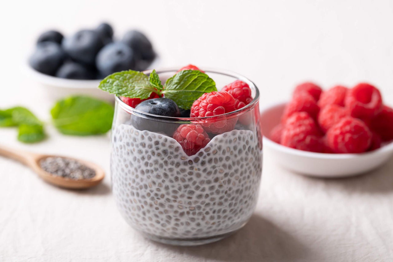 Cup with chia seed pudding topped with mixed berries.