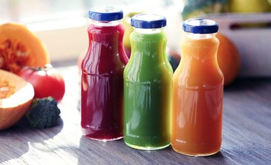 Three different juices sitting on a table or counter