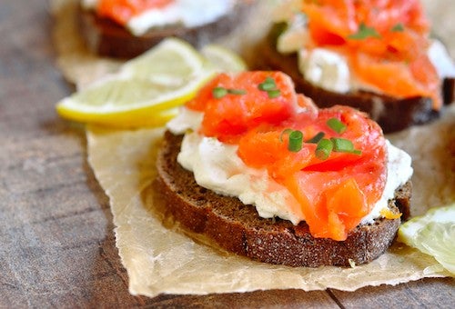 Sandwich with salted salmon and cream cheese on rustic background.