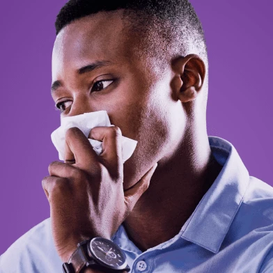 Man holding a tissue to his nose