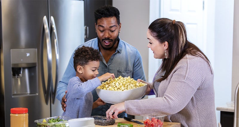 Couple and child with popcorn.
