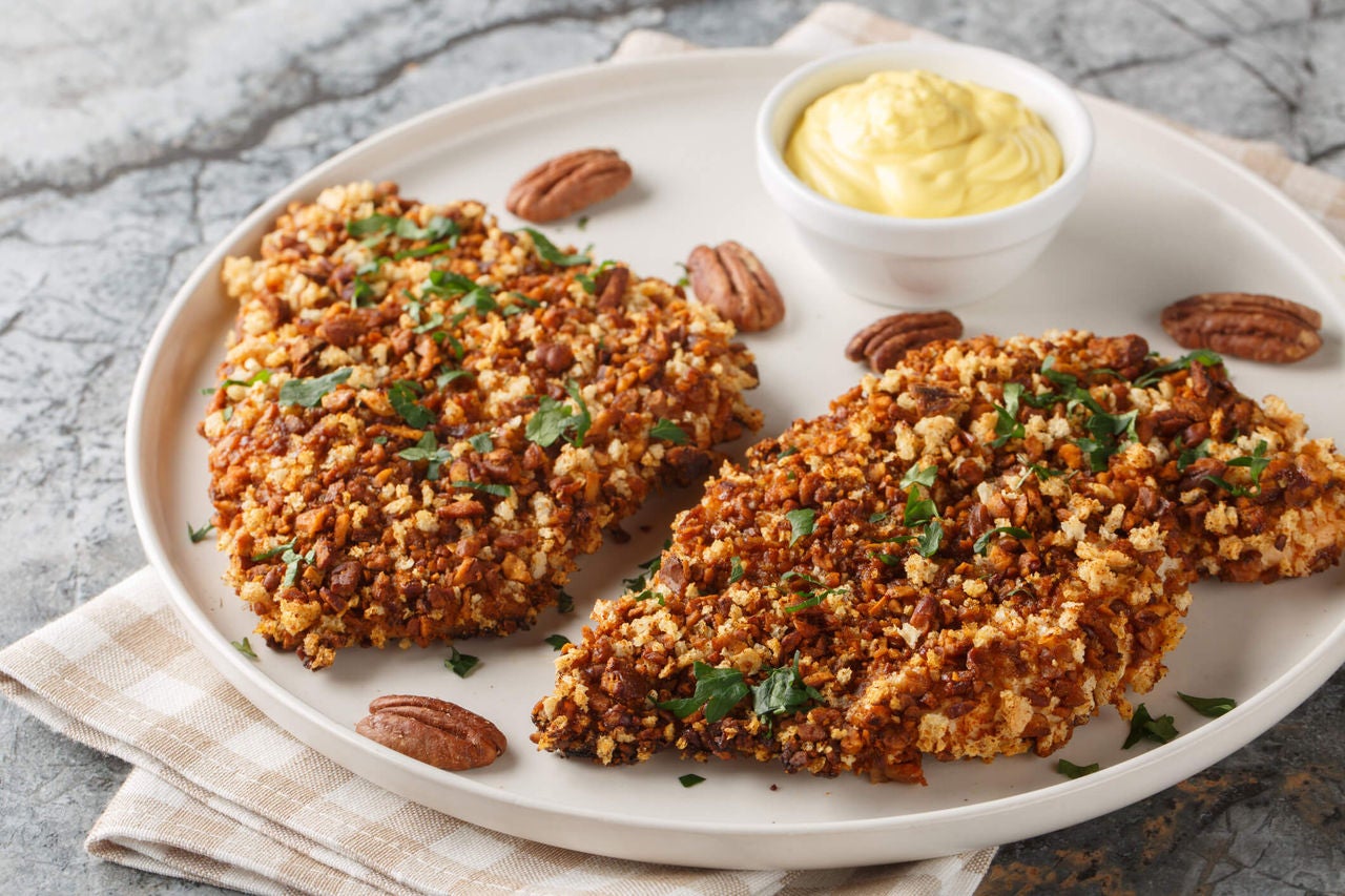 Pecan crusted fish fillets on a plate.