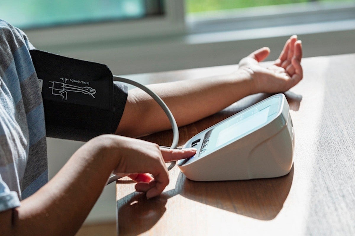  Person taking a blood pressure with their arm on a table