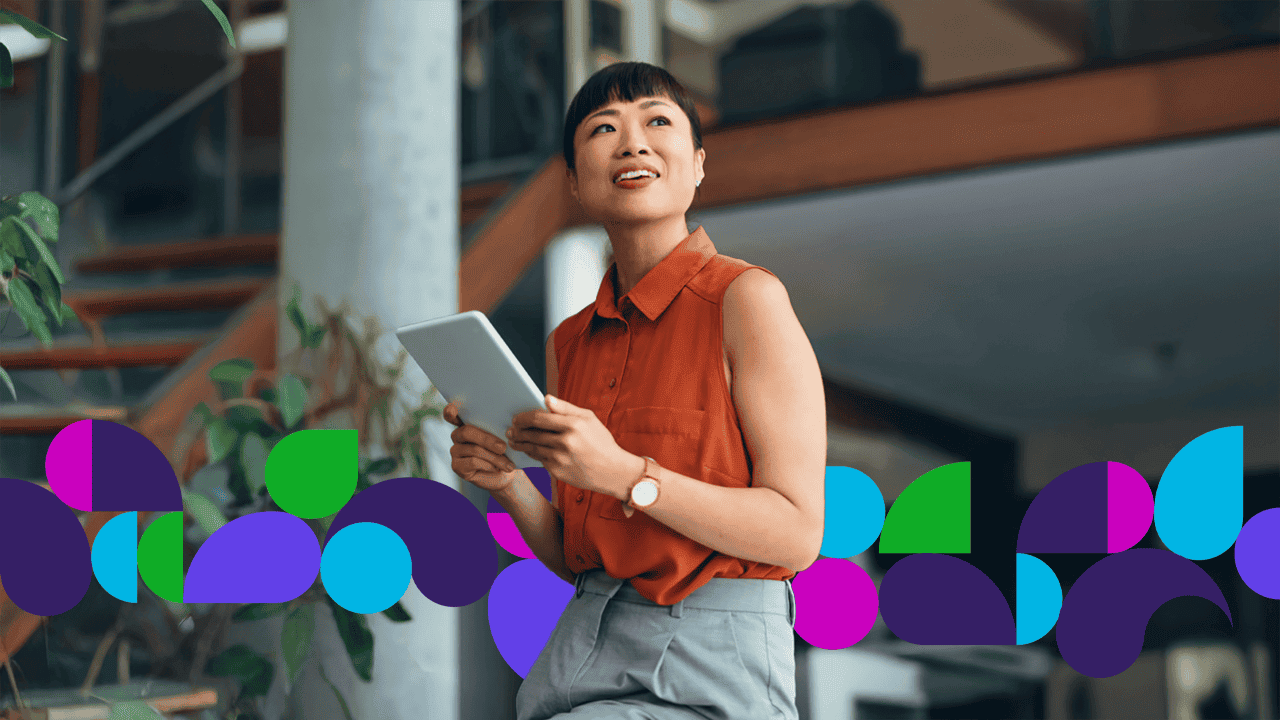 Woman holding a tablet smiling and looking off into the distance