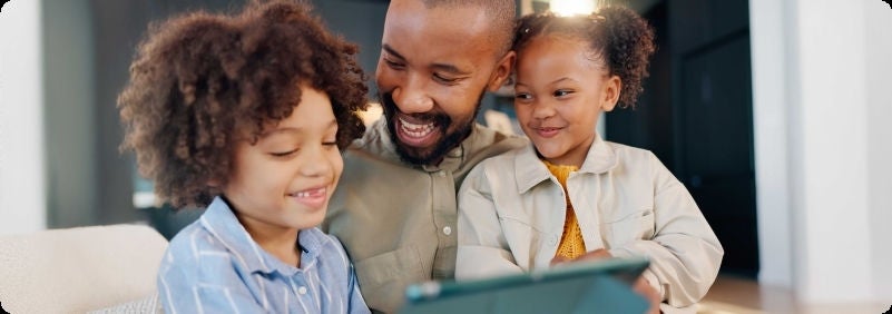 Father and his kids using a digital tablet in the living room.