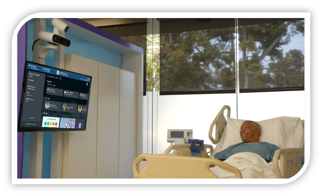 Patient in a hospital bed smiling at a wall-mounted screen showing a virtual nurse on a video call.