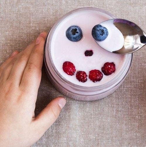 Berries arranged in a smiley face on top of yogurt