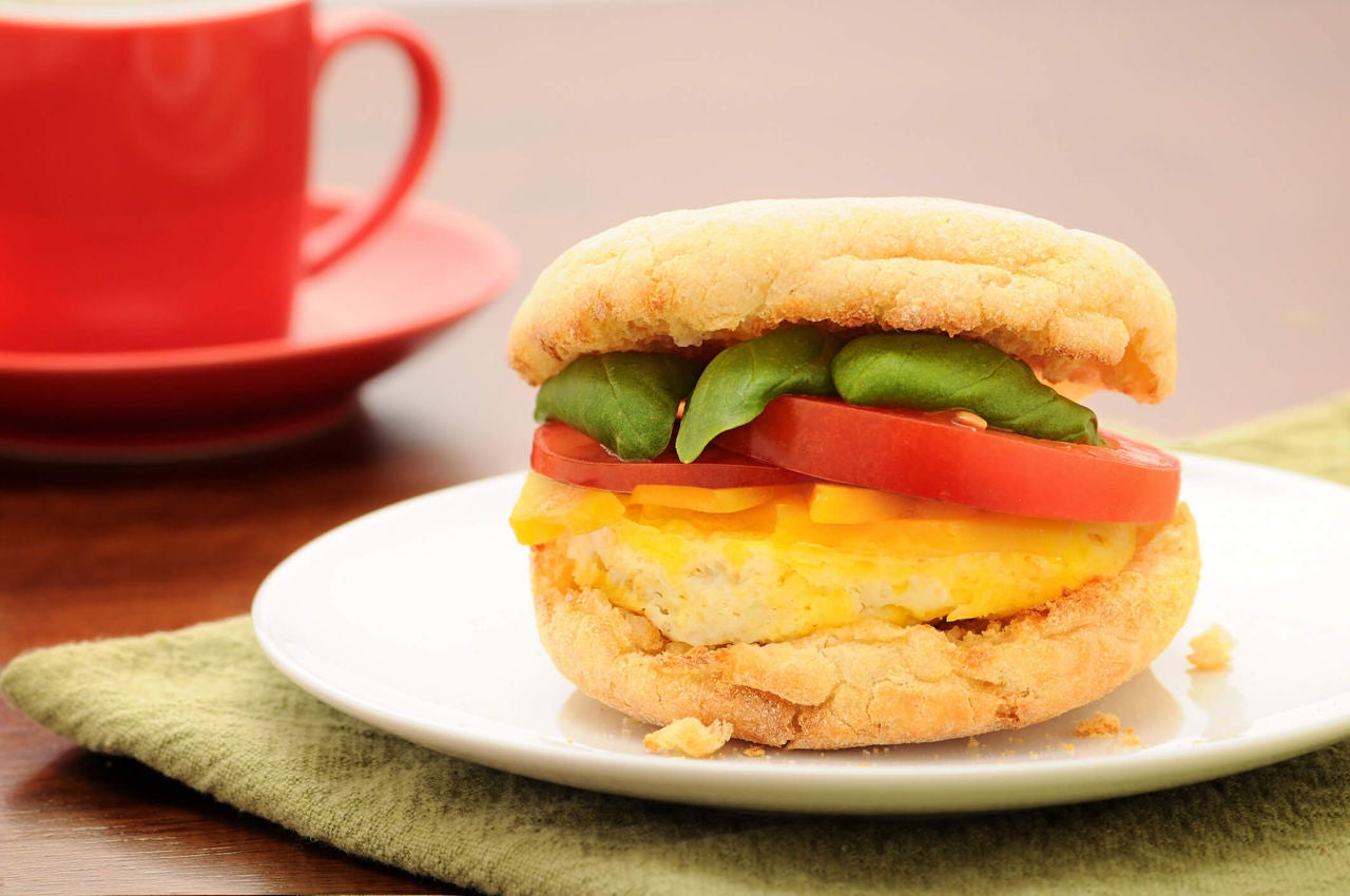 Egg breakfast sandwich with tomatoes, spinach and cheese.