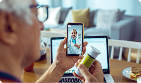  A man speaks virtually with a healthcare provider while holding a bottle of prescription medication.
