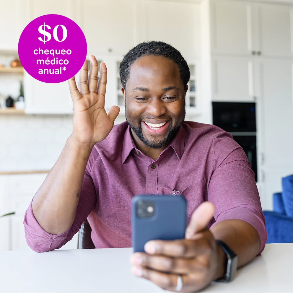 A man speaks to a healthcare provider using his phone while sitting in his home.