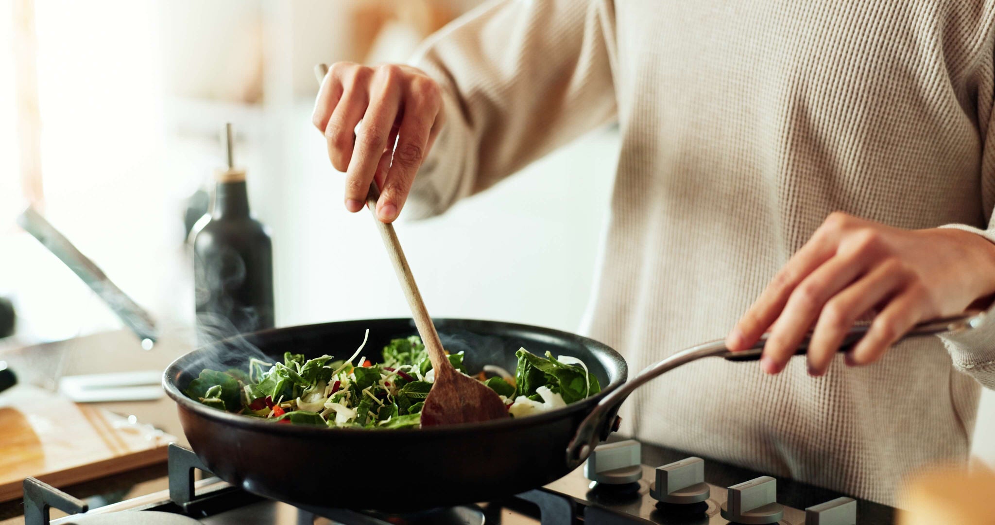 Person stirring ingredients in a frying pan. 