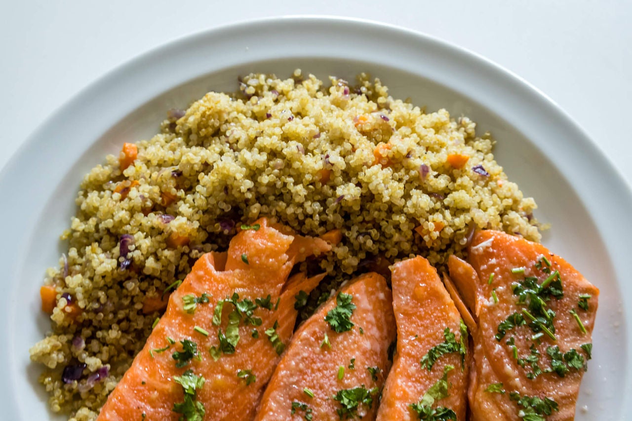 Salmon fillets with seasoned quinoa on a white plate.