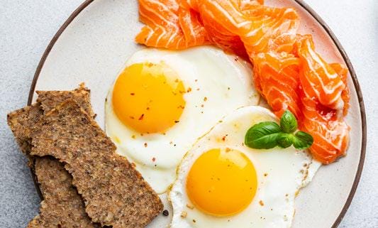 Plate with eggs, toast, and salmon.