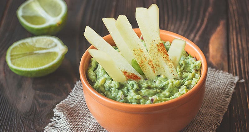 A bowl of guacamole garnished with jicama