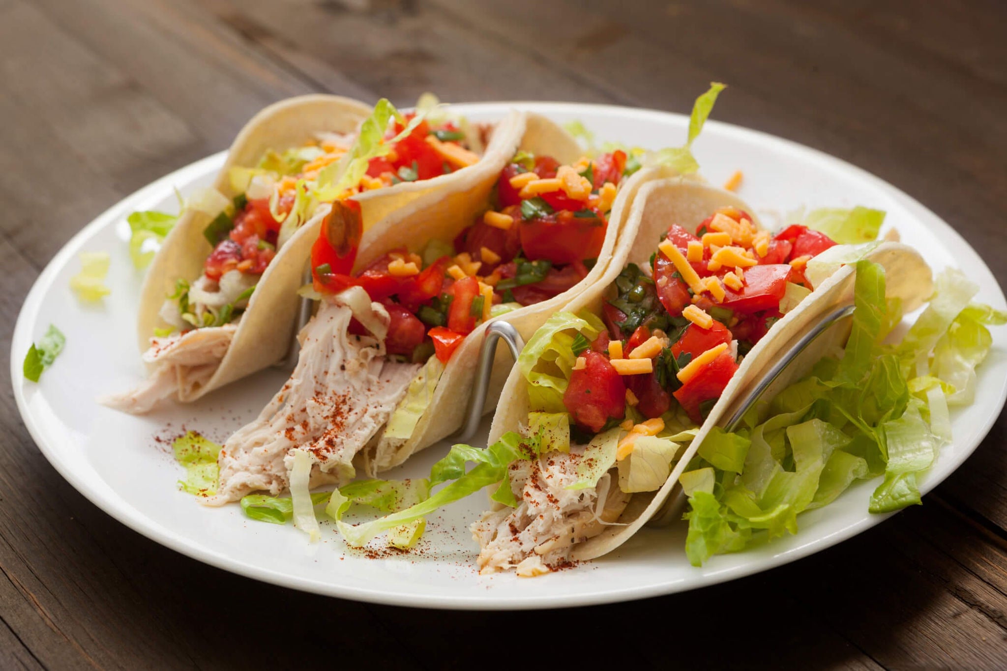 Soft tacos filled with shredded chicken, lettuce, and pico de gallo