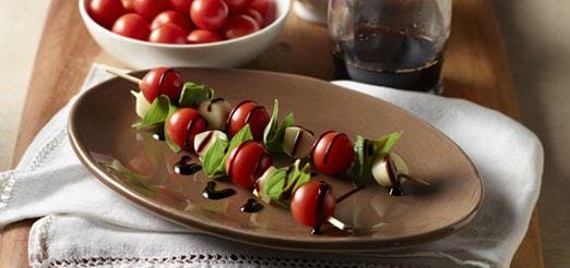 2 caprese skewers on an oval plate