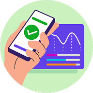 Hand holding mobile phone with a check mark on the screen and a screen with charts on it in the background