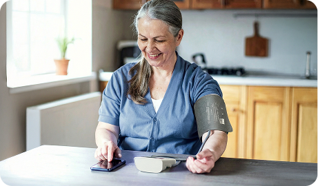  A woman uses a medical device to take her blood pressure reading.