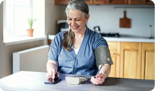  A woman uses a medical device to take her blood pressure reading.