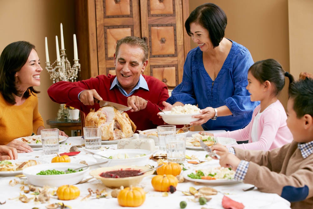 Multi generation family celebrating thanksgiving around a set table