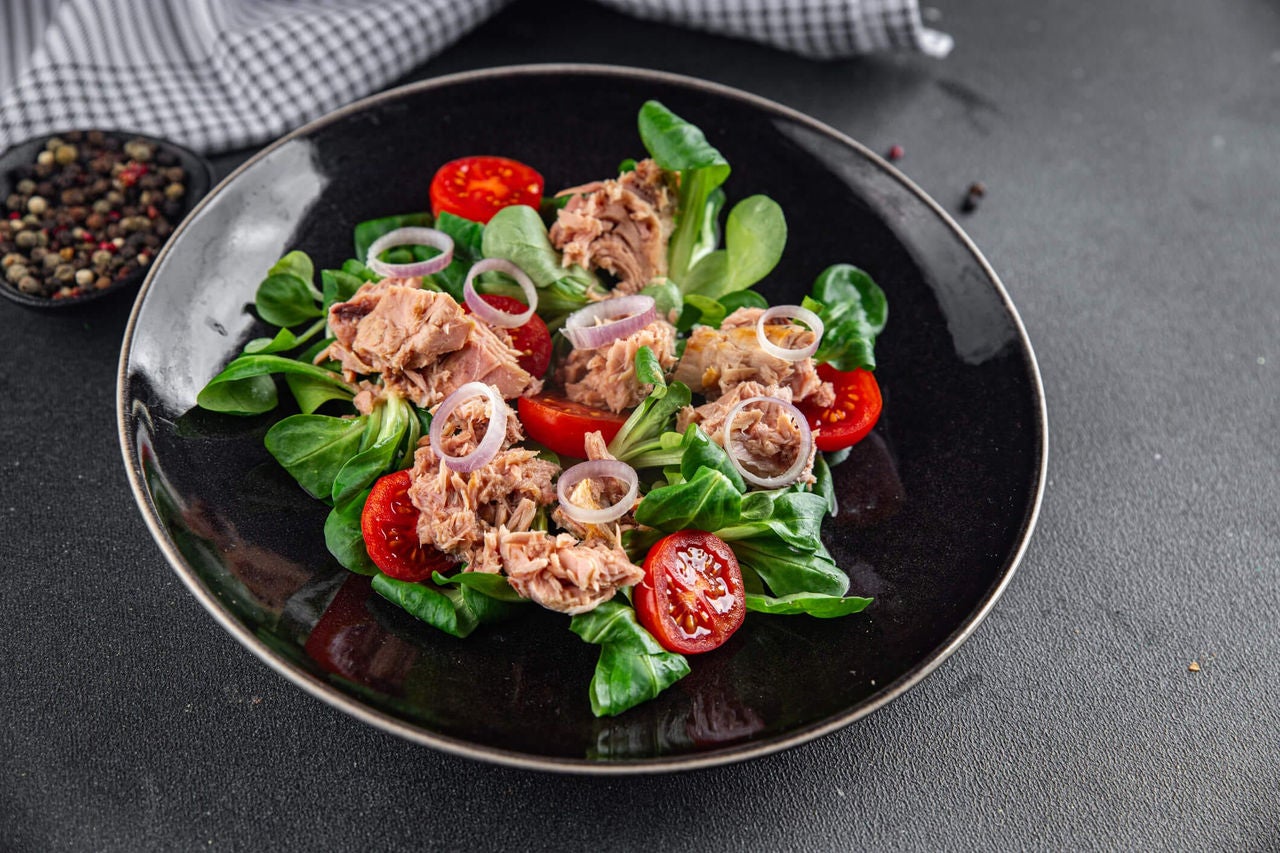 Salad with tuna, tomatoes, red onion, and leafy greens