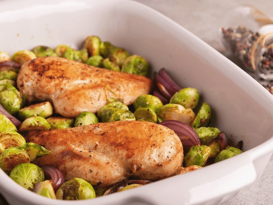 Pan with seasoned chicken, brussel sprouts and red onions.