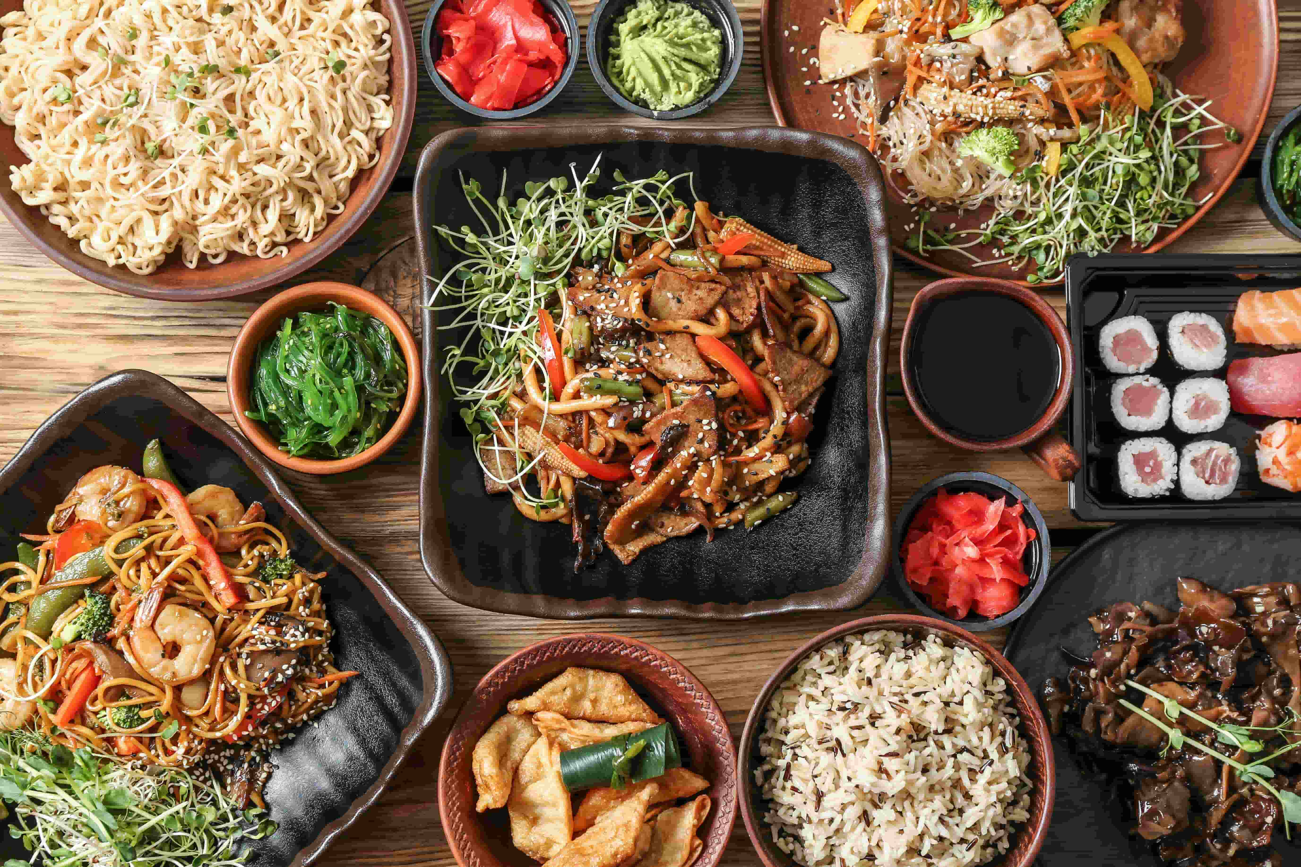 Overhead view of an assortment of East Asian dishes. 