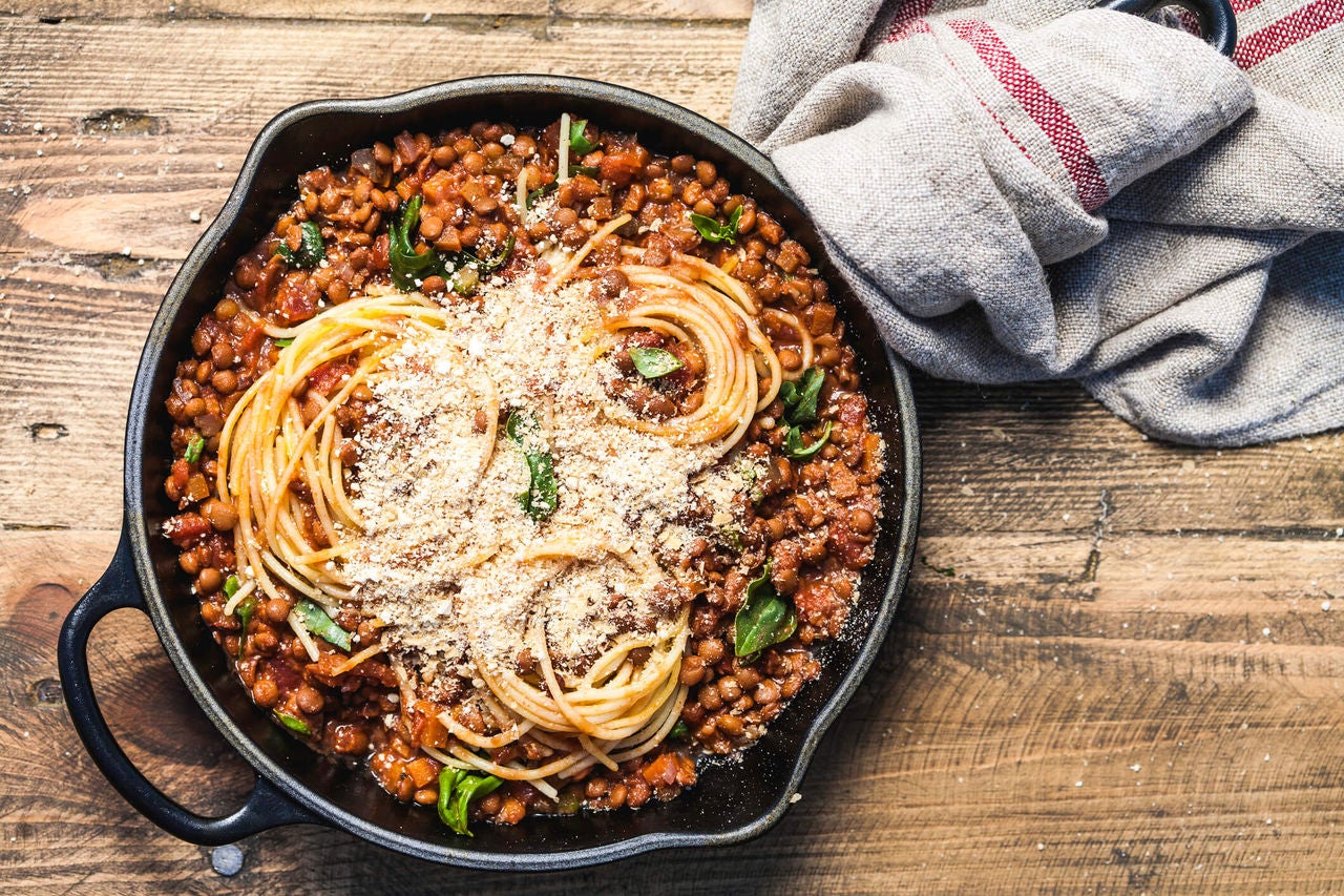 Spaghetti with sauce and whole lentils with herbs and parmesan cheese.