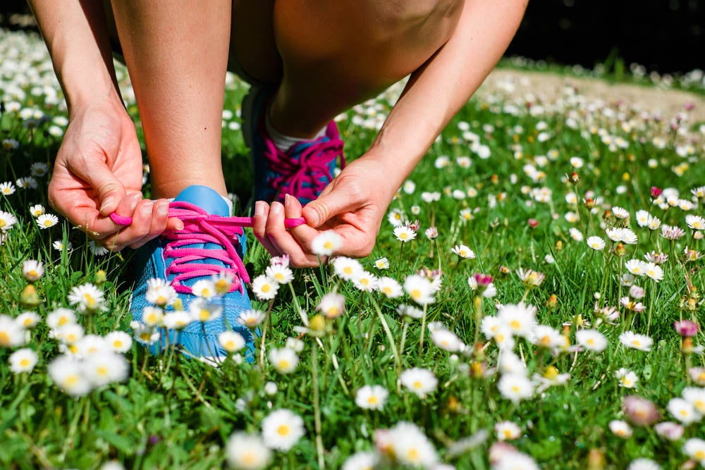Female athlete getting ready for running in spring park. Fitness workout outdoor concept.
