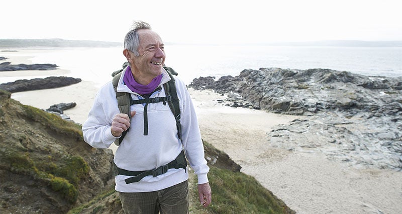Older man hiking near the ocean.