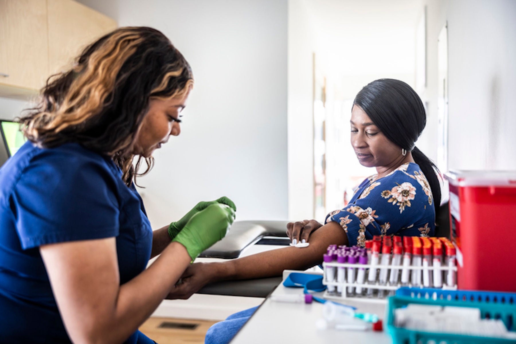Woman taking a blood sample from another woman