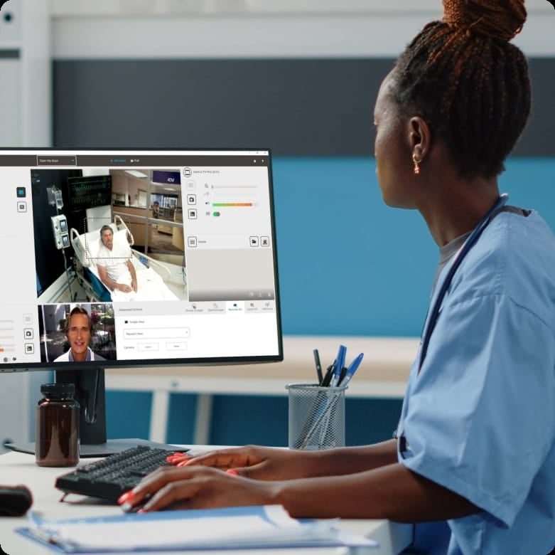 Clinician monitoring a hospitalized patient through a virtual care platform on a desktop computer