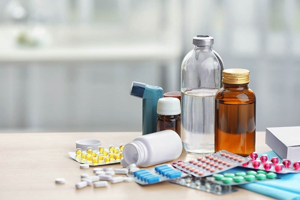Different medicines and pills on wooden table