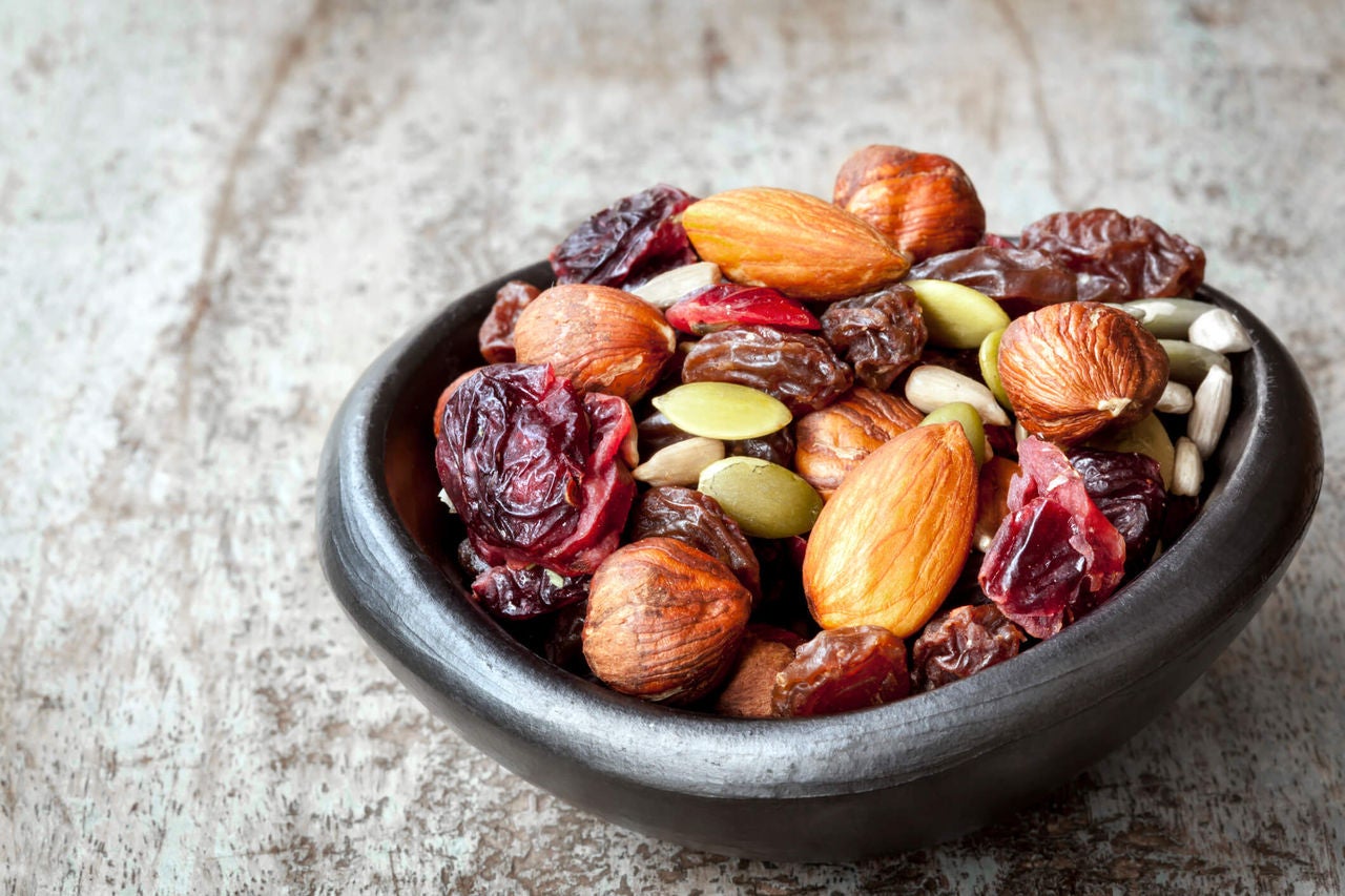 Bowl of trail mix with dried cherries and seeds.