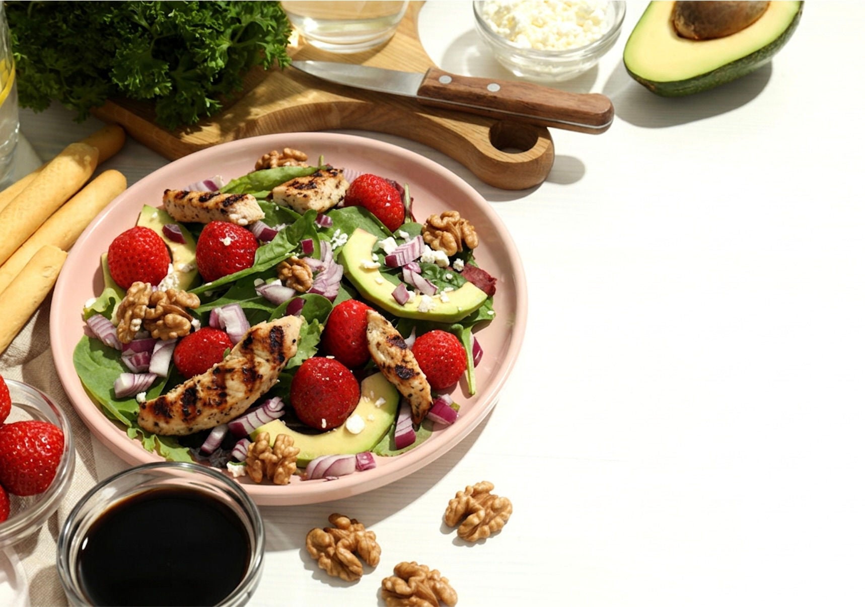Bowl with spinach leaves, strawberries and walnuts.