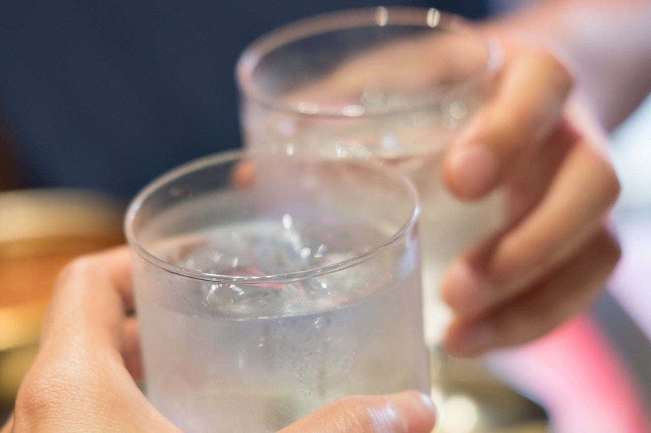Two people toasting with glasses of water