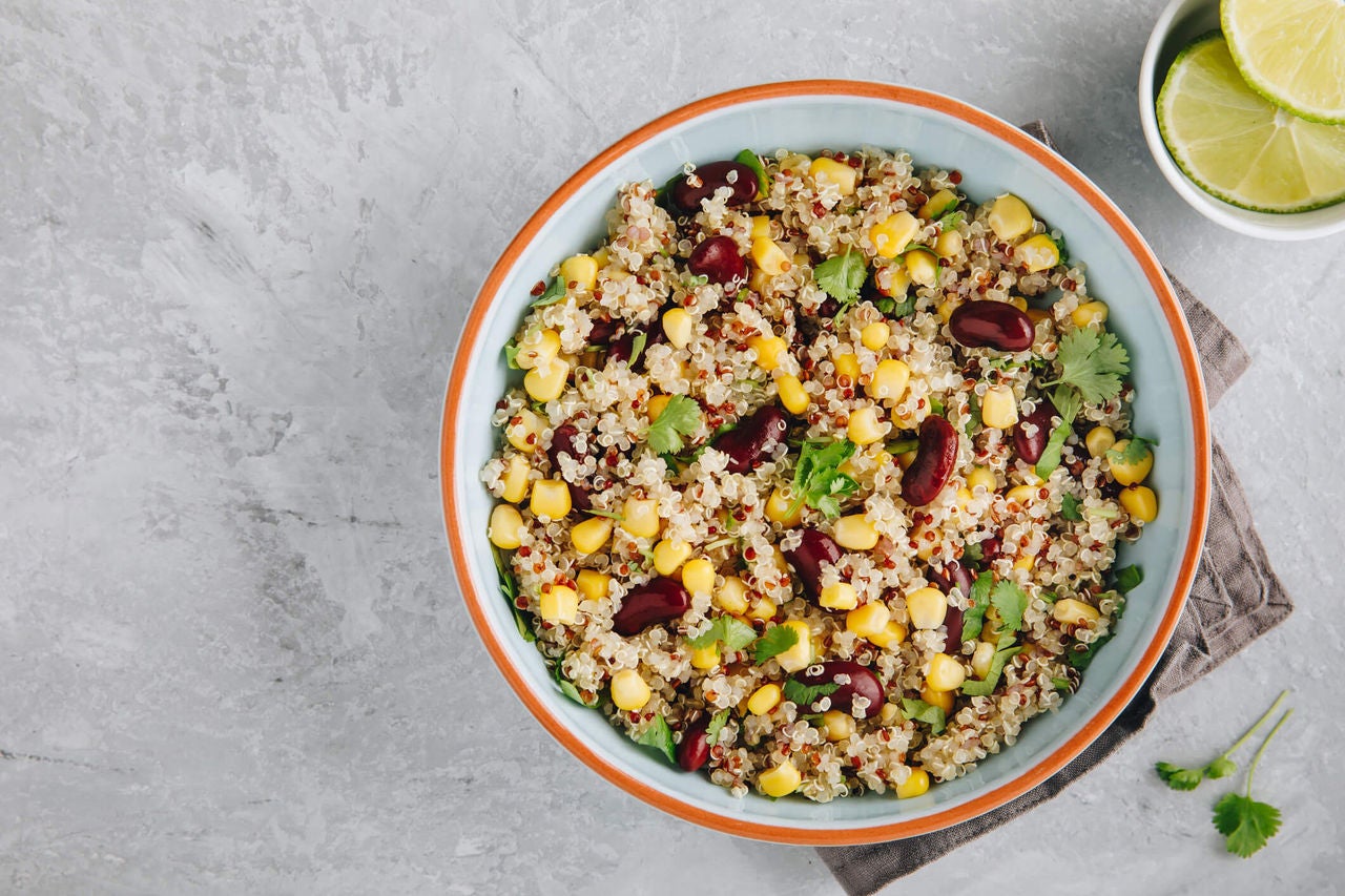 Bowl with lettuce, quinoa, corn, beans and greens.