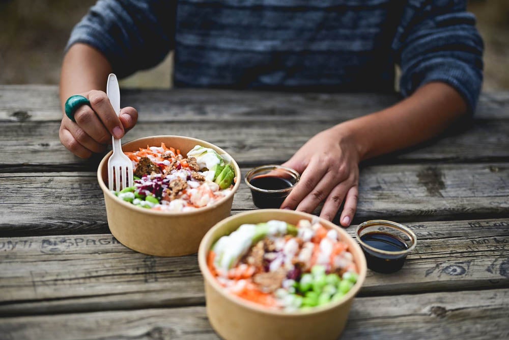 Persona comiendo un bowl saludable al aire libre