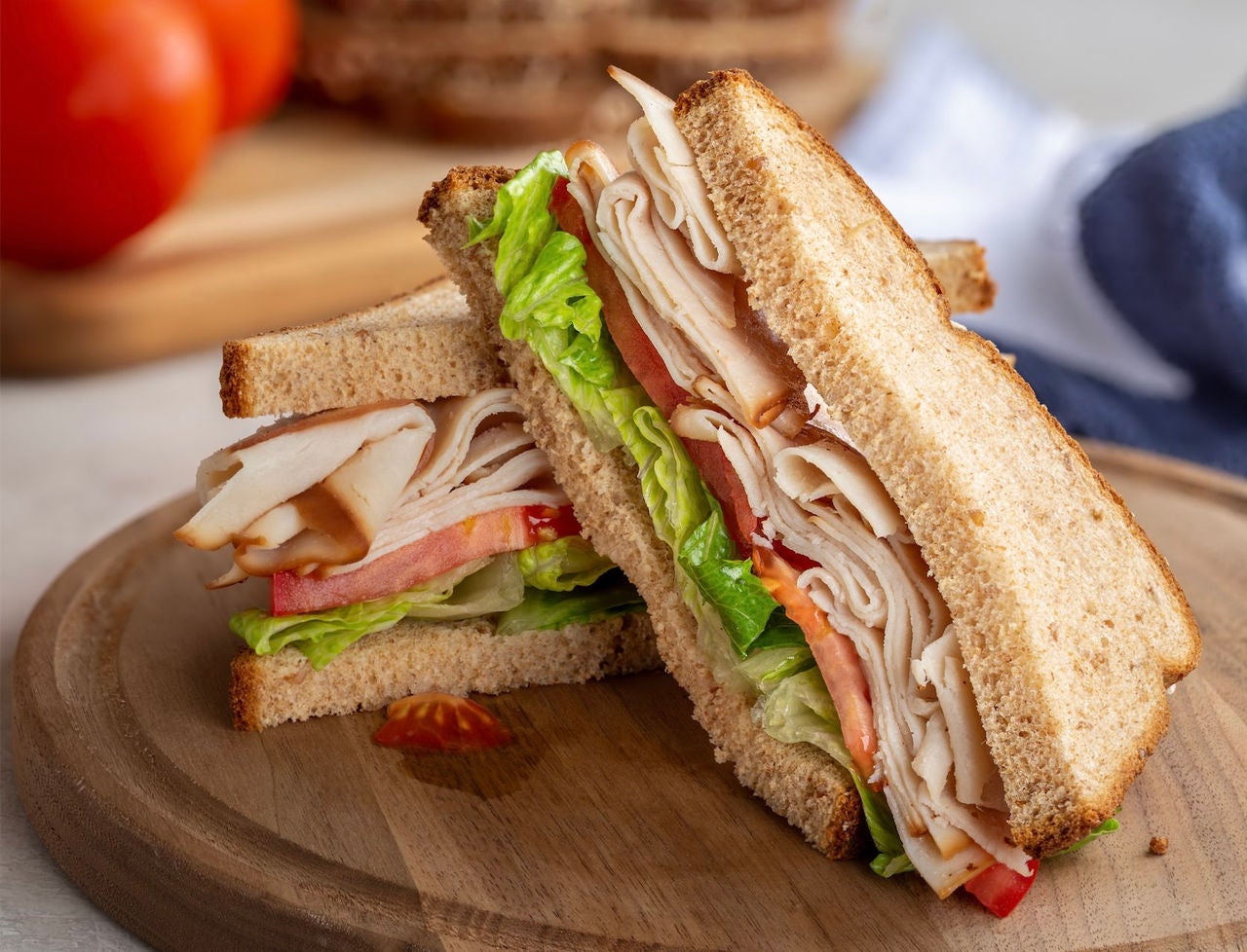 Sandwich with turkey, lettuce and tomatoes.